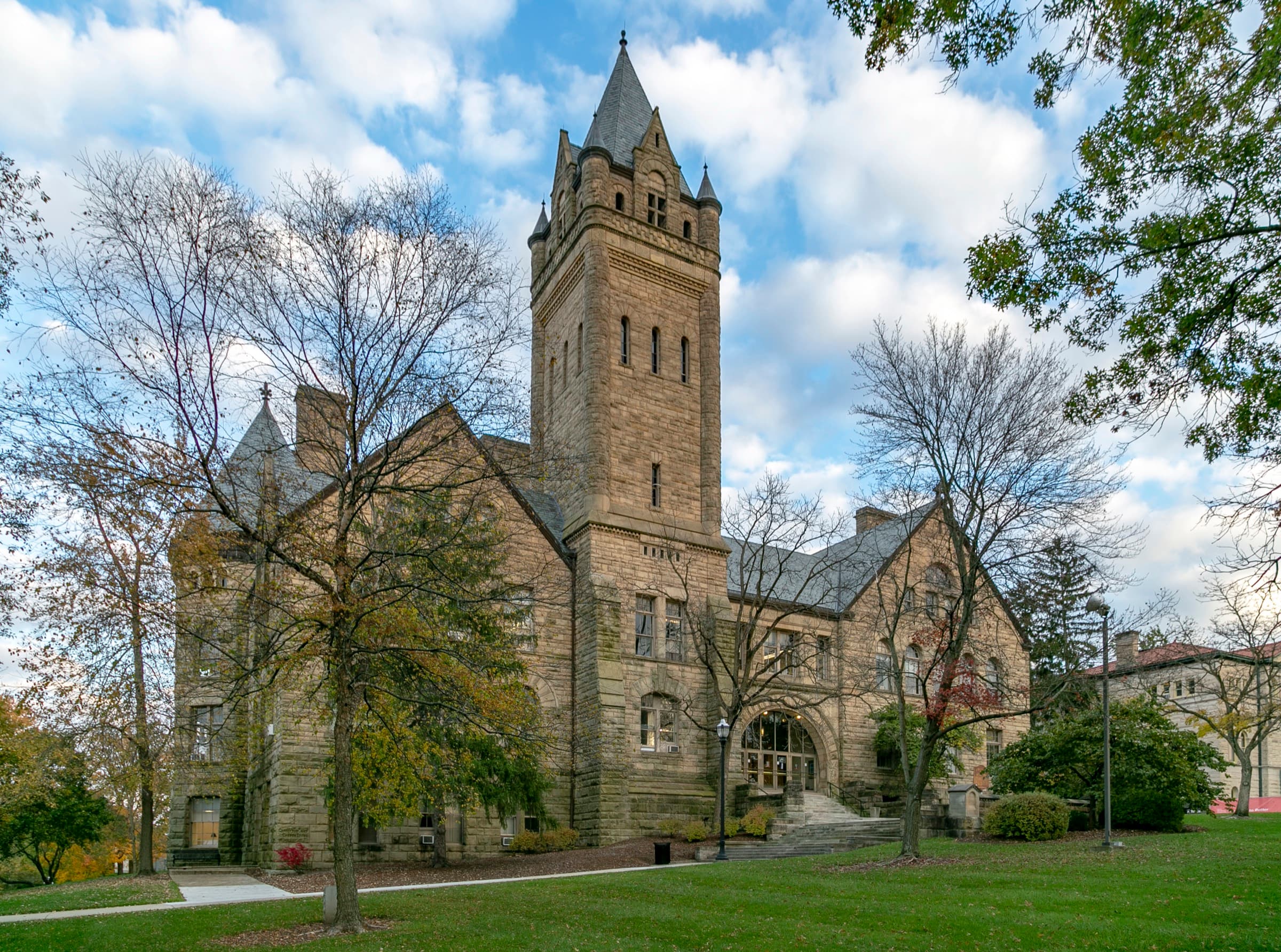 Ohio Wesleyan University's stone University Hall from 1893 and its clock tower framed by golden autumn trees