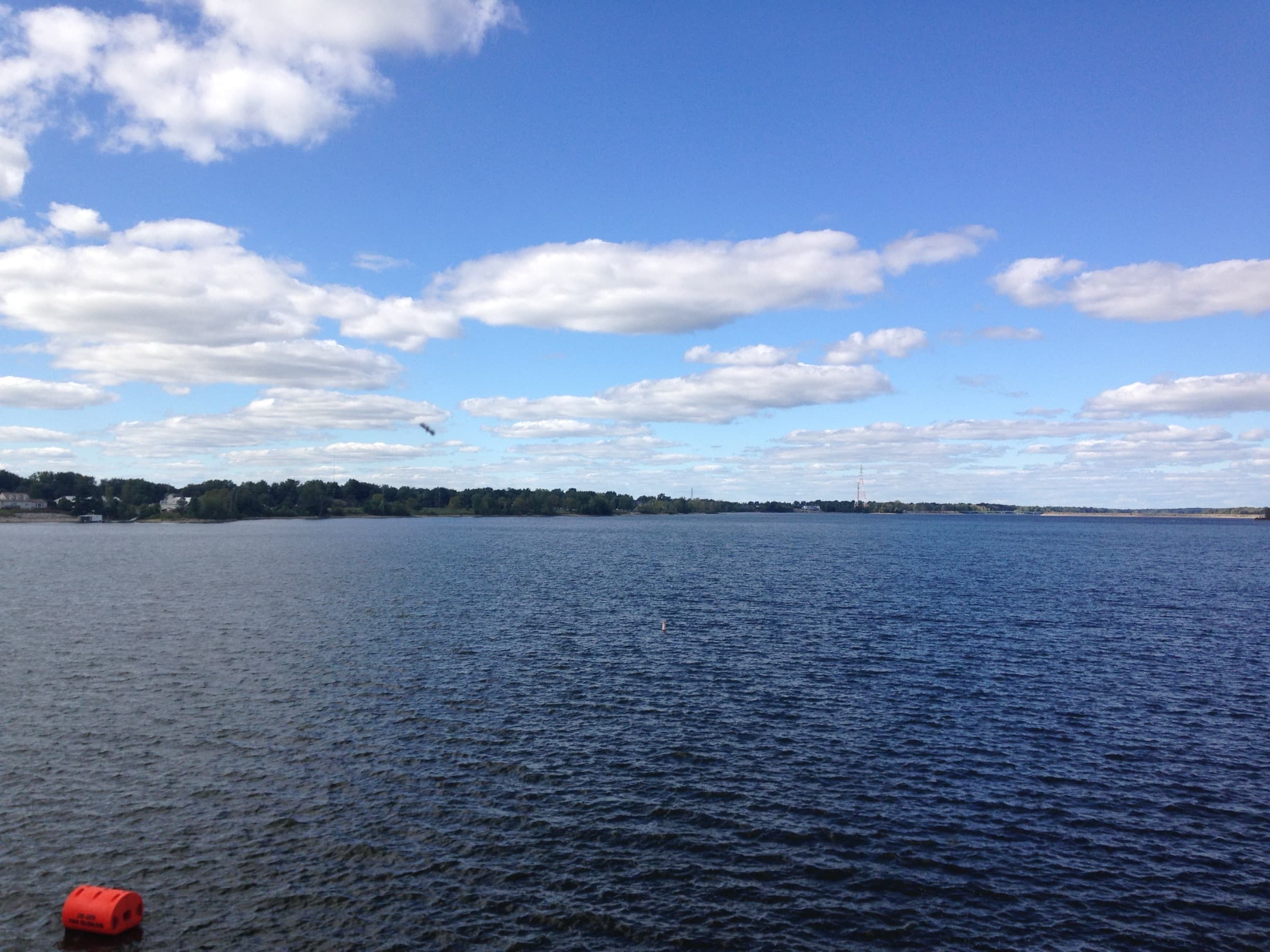 Late-summer view across the open water of Hoover Reservoir with green tree-lined shoreline