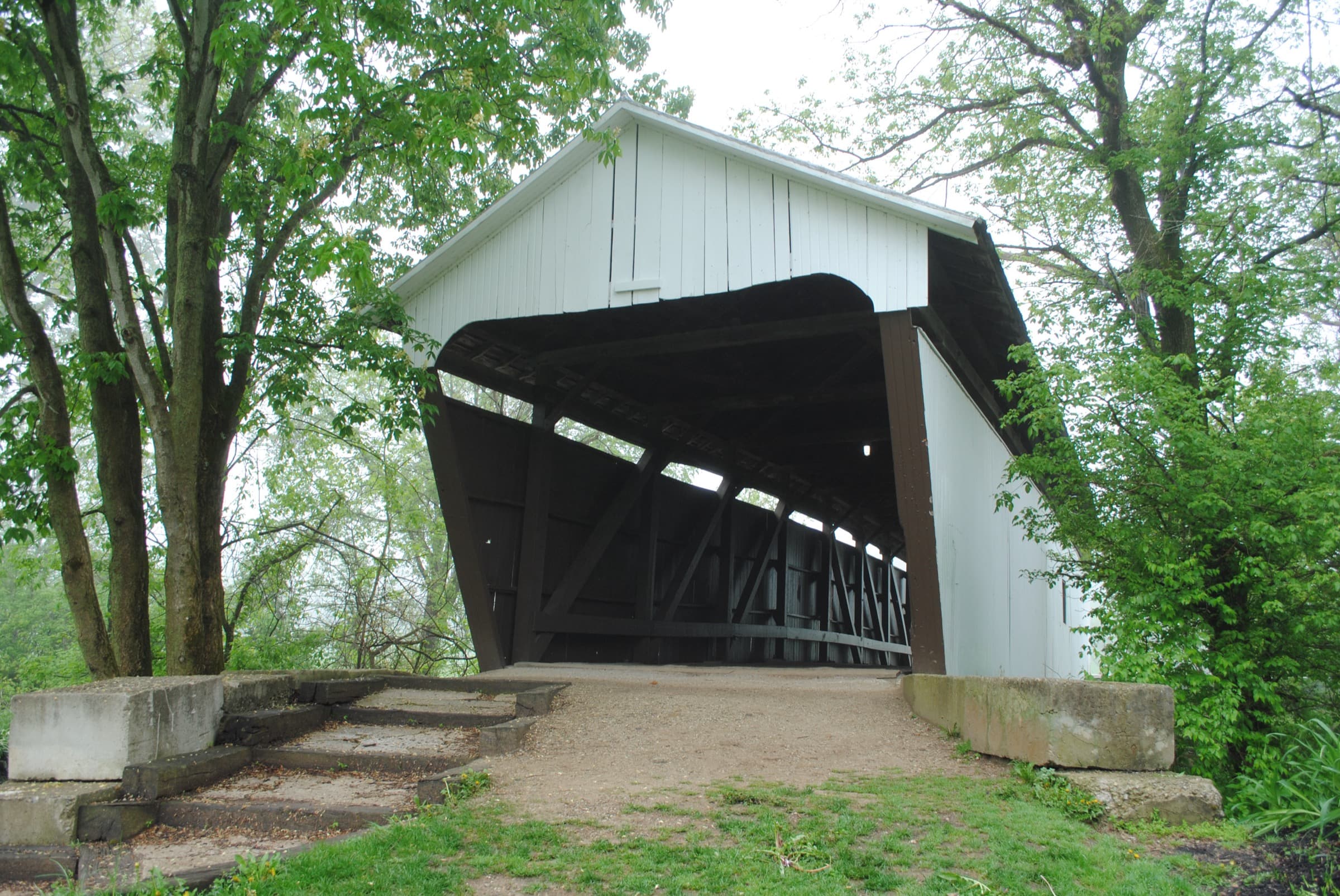 The white 1906 Zeller-Smith Covered Bridge framed by spring foliage in Sycamore Creek Park